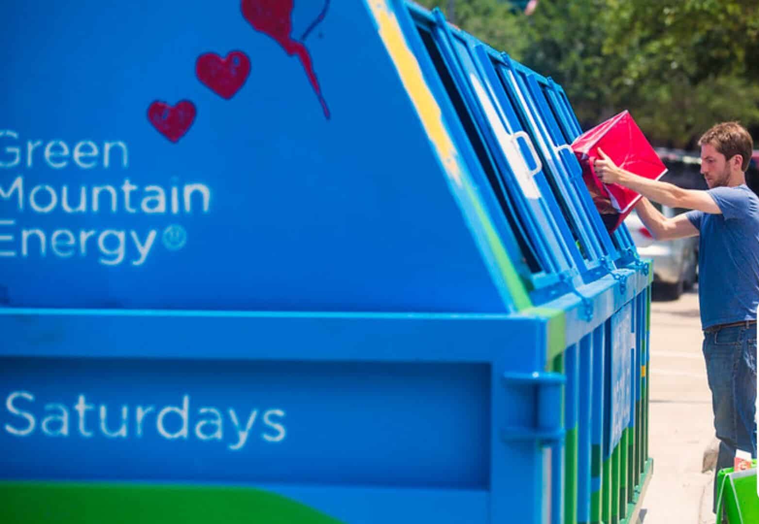 Man dropping their recyclables into the bin at Discovery Green in Downtown Houston