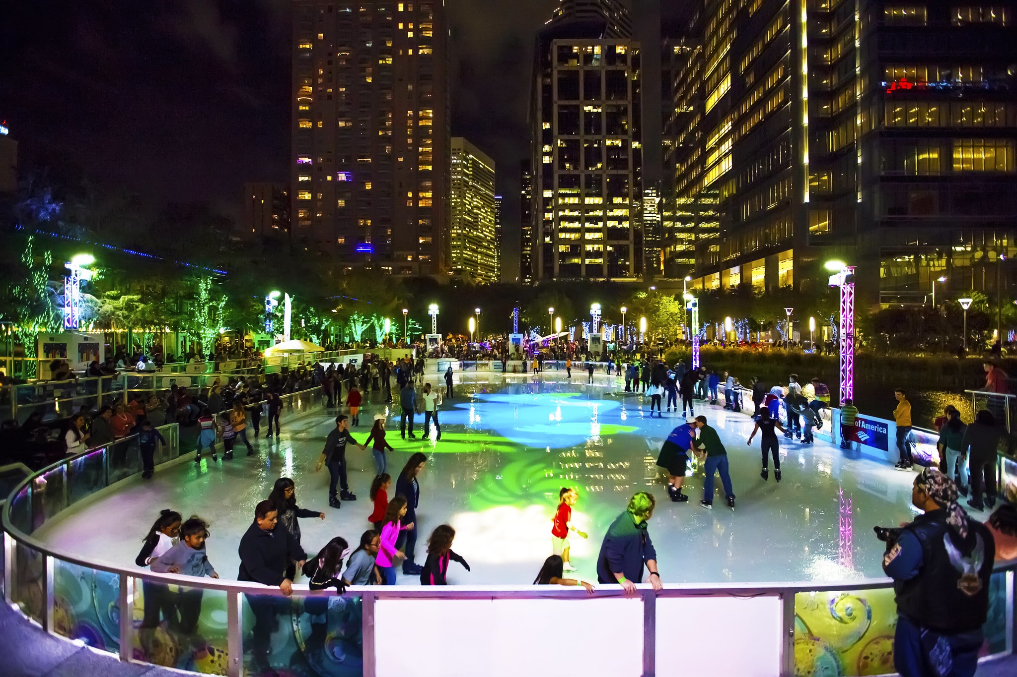 People ice skate outdoors in downtown Houston at Discovery Green.