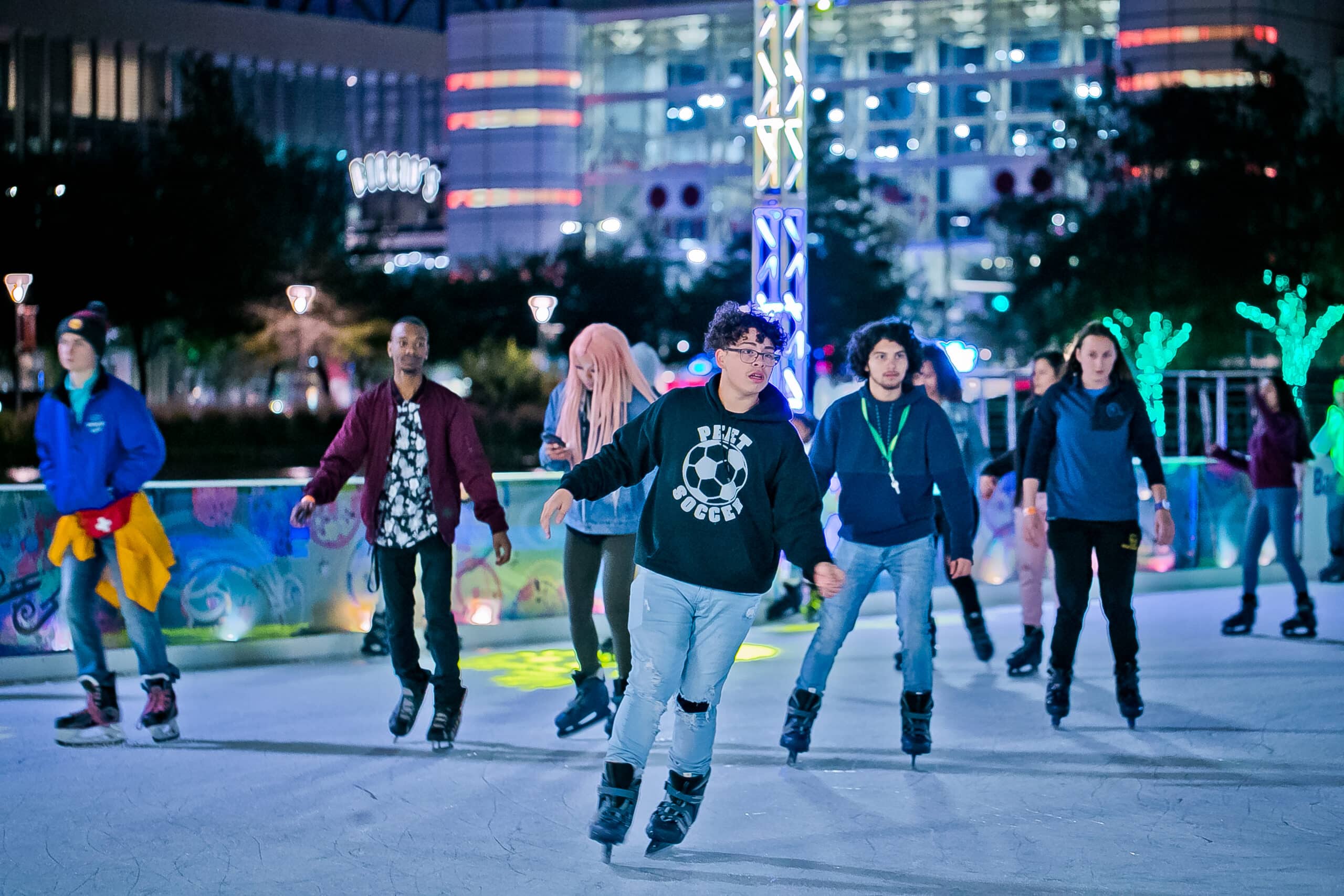 Students ice skating in downtown Houston, Discovery Green for a discounted price.